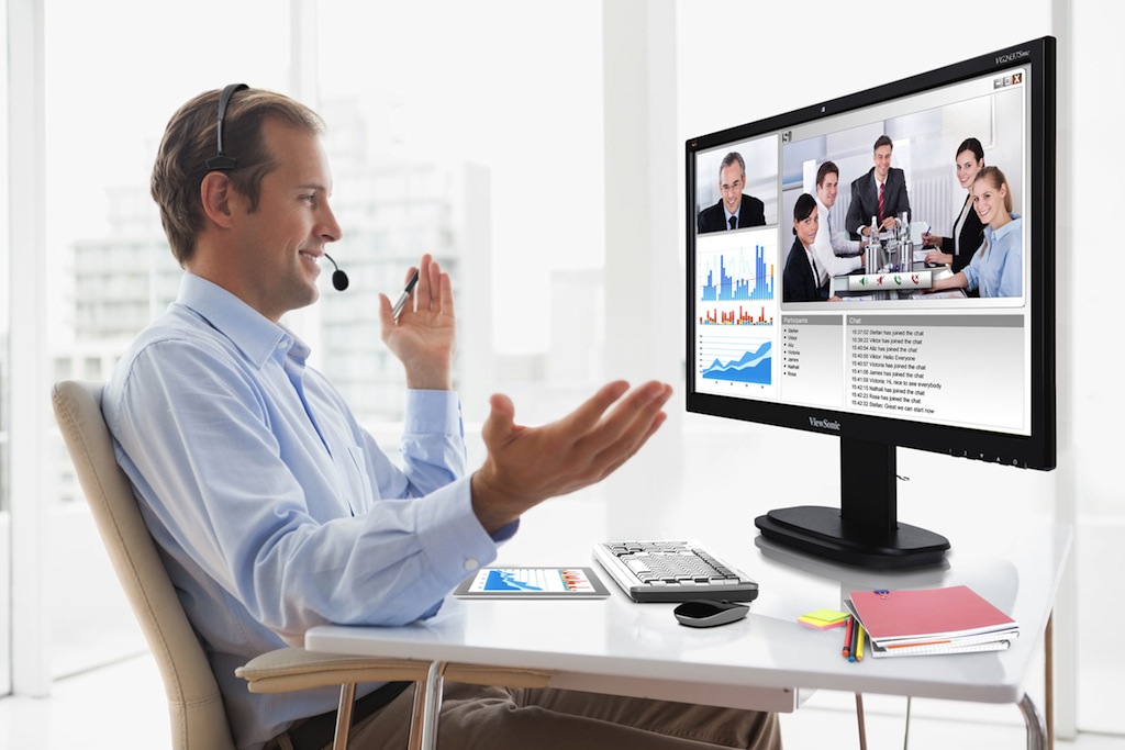 Smiling businessman sitting at his desk on video chat